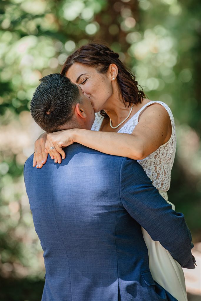 Clara enlacée à Stéphane sous les arbres, le jour de leur mariage