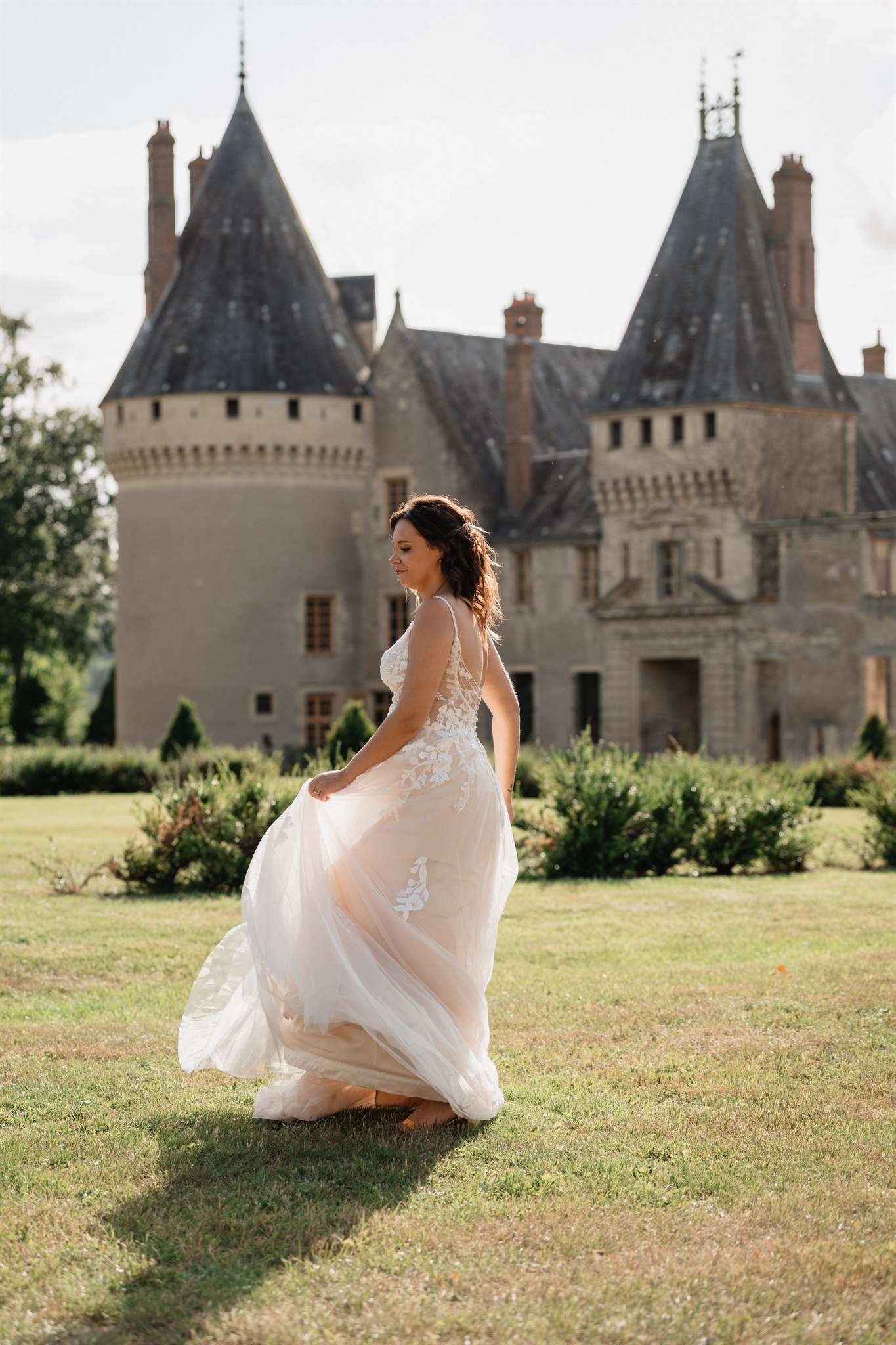 Mariée devant un château de la Nièvre, robe au vent