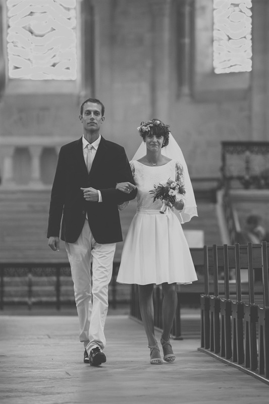 La mariée au bras de son père remontant l’allée de l’église, noir et blanc