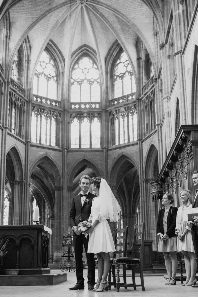 Mariage à la Cathédrale de Nevers – Les mariés échangent un regard complice dans la majestueuse nef gothique.